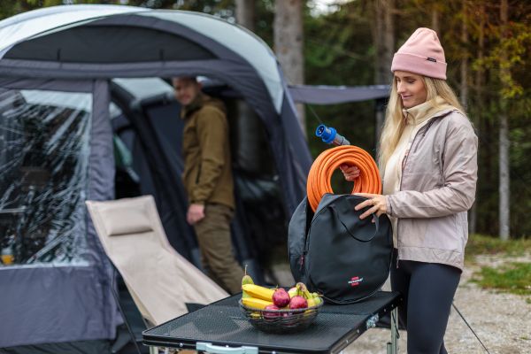 Een vrouw haalt de CEE campingverlengkabel uit de opbergtas